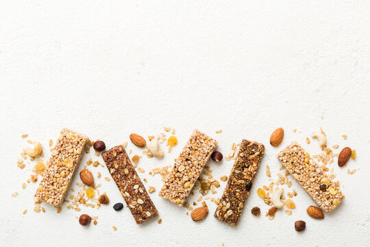Various granola bars on table background. Cereal granola bars. Superfood breakfast bars with oats, nuts and berries, close up. Superfood concept
