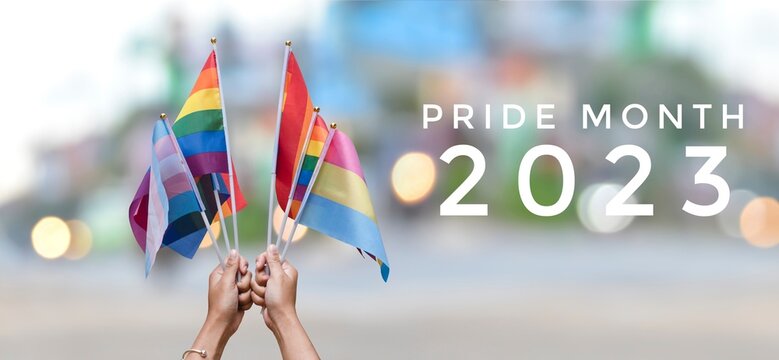 'Pride Month 2023' on rainbow flags and street bokeh background, concept for lgbtq+ people celebrations in pride month, June, around the world and calling out people to respect gender diversity.