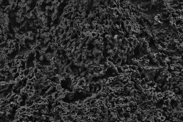 Dark abstract texture of rough rock texture. Sandy wrinkled background in the dark, black surface