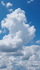 Tranquil vertical background: blue sky and cotton-like white clouds