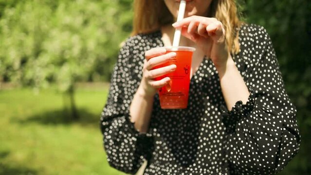 female's hand holding bubble tea glass with straw outside. High quality FullHD footage Generative AI
