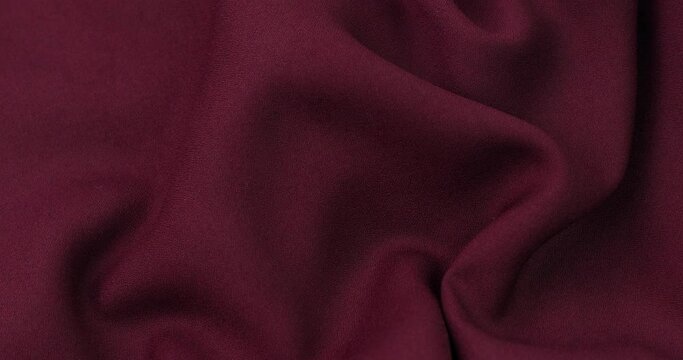 Burgundy fabric background. Burgundy cloth waves background texture. Burgundy fabric cloth textile material.