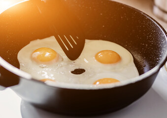 Person preparing fried eggs