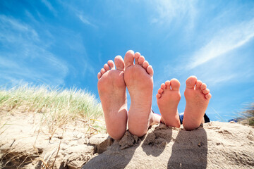 Fototapeta na wymiar Family feet relaxing and sunbathing on the beach background concept for vacation and summer holiday