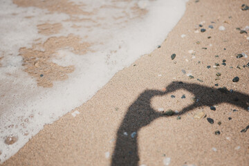 Girl hand in heart form love with ocean sunset background