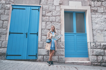 Travel and active lifestyle concept. Young traveller woman walking on old town holding tourist map.
