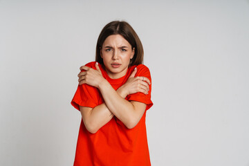 Annoyed woman shivering with cold isolated over white background