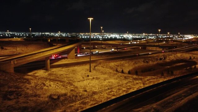 Aerial orbit around car crash below highway overpass at night
