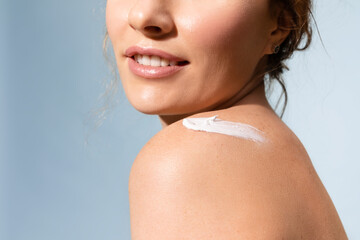 Woman with   cream on  shoulder, enjoy soft and shiny skin.