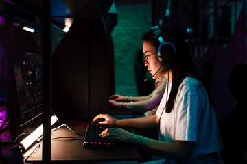 Asian girl playing online video game in cybersport club © Drobot Dean