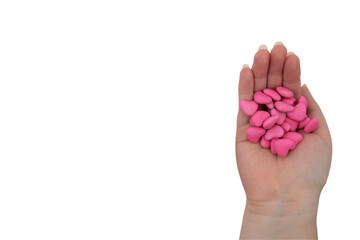 A handful of pink sweets in the shape of a heart in a hand isolated on a transparent background