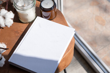 Magazine and book mockup design. Blank magazine on modern wooden table with candles , shadow overlay