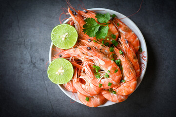 Fresh shrimps prawns seafood lemon lime with herbs and spice, shrimp on white bolw and wooden background dining table food
