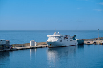 Naklejka premium Passenger pax cargo car roro ro-ro ferry boat vessel cruiseship cruise ship liner in Palma de Mallorca, Spain port with city skyline and cargo harbor