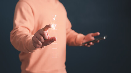 Young man using finger tick the virtual screen correct sign mark for document approval and...