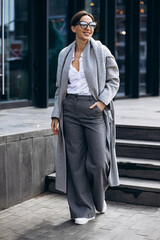 Beautiful business woman in grey coat outside office building