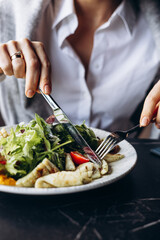 Woman drinking coctail and eating salad in a cafe