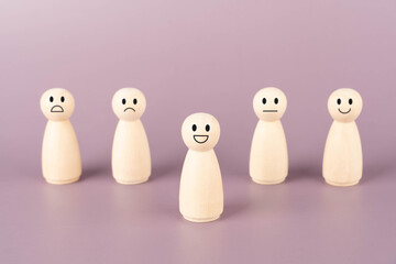 Happy smile icon on wooden doll that showing emotions and scores. Customer review, satisfaction, feedback survey, mental health assessment concept.