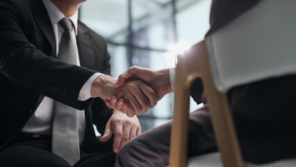 Close up businessman shaking hands with caucasian client.