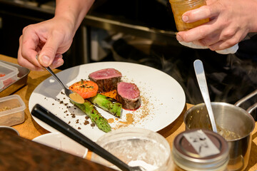 料理を盛り付けるシェフの手元