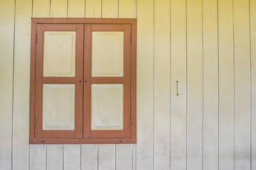 Closed Old wooden window with shutters on an wooden wall. Window on indonesian malay traditional house. Sumatran traditional house. Empty Blank Text Space.