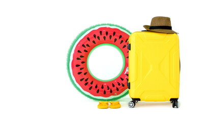 Summer travel concept. Colorful inflatable balls, sandals, yellow suitcase and straw hat with a black stripe on white background. (Studio Shot)