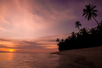 Durai Island, Anambas Islands, Indonesia while sunset with coconut trees silhouette. Empty blank copy text space. Concept for travel, tourism, slow life, relaxation, holiday, vacation.