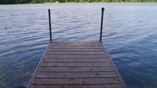 Looking down at a dock on a sunny lake in Ontario in summer.