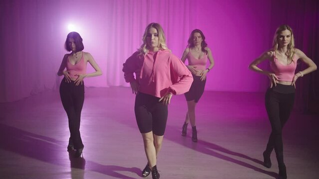 Group class with a high heels trainer in the dance hall. A beautiful girl shows the rhythms of a dance class of girls. High quality 4k footage Generative AI