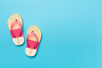 Bright flip flops on color background, top view