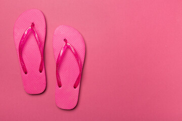 Bright flip flops on color background, top view