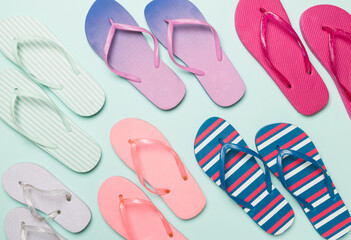 Bright flip flops on color background, top view