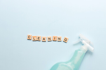.Word cleaning from wooden letters. Spray for cleaning. Cleaning agent. Purity. Flatly cleaning on a blue background