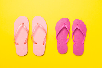 Bright flip flops on color background, top view