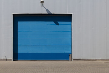 Industrial blue roller shutter door for loading dock in factory building.
