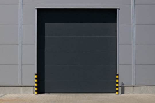 Industrial grey roller shutter door for loading dock in factory building.