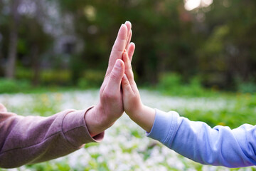 Father holds daughter by the hand close-up. nature background, Support and family love