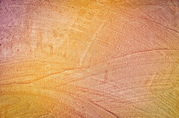 Coloroful wall texture in grunge background. Orange pink stone background with hand-made patterns.