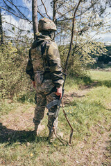 A special forces soldier guards the area. A soldier with an assault rifle in camouflage with tactical equipment. various camouflage