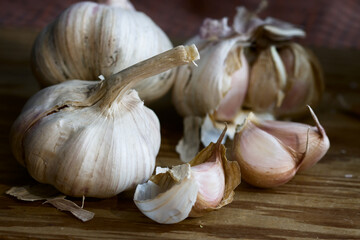 closeup of some heads of purple garlic on a wooden board