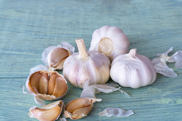 Garlic bulbs and garlic cloves on old wooden background.