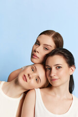 Portrait of young beautiful girls without makeup on face looking at camera over blue studio background. Beauty injections