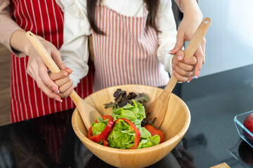 Happy Pretty mom and lovely daughter preparing healthy food in kitchen