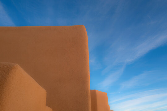 United States, New Mexico, Santa Fe, Adobe style walls against blue sky 