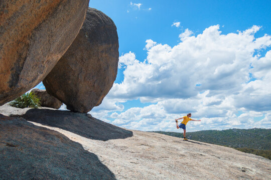 Australia, Queensland, Girraween National Park, Man exercising next to large boulder