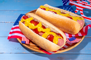 USA Patriotic picnic holiday hot dogs.  American patriotic hot dog on wooden board plate, with USA flag. Celebrating Independence day on 4th July, Memorial or Veteran Day