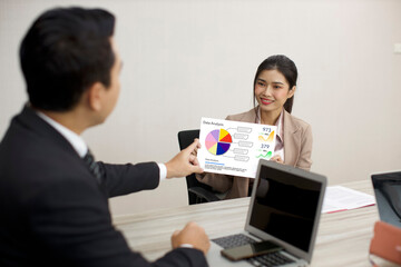 Collaborative process of professional businesspeople using paperwork and going over on meeting presentation with growth analysis, charts, statistics and data at office meeting concept.