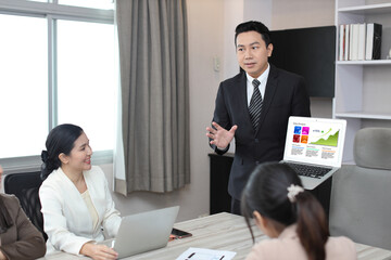 Collaborative process of professional businesspeople using computer and going over on meeting presentation with growth analysis, charts, statistics and data at office meeting concept.
