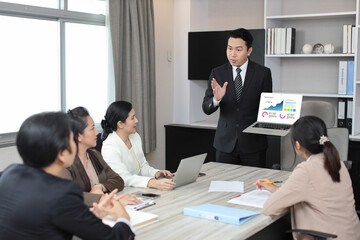 Collaborative process of professional businesspeople using computer and going over on meeting presentation with growth analysis, charts, statistics and data at office meeting concept.