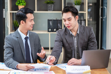 Asian business team consists of marketing staff. accountant and financial officer Help each other analyze company profits using tablets. calculator Laptop computers, graph paper, and corporate pens.